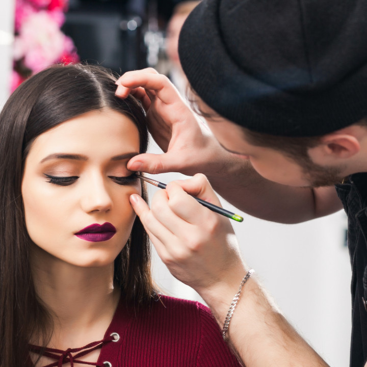 professional makeup artist applying editorial makeup look on client model