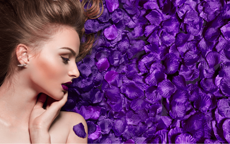 model lying in purple rose petals