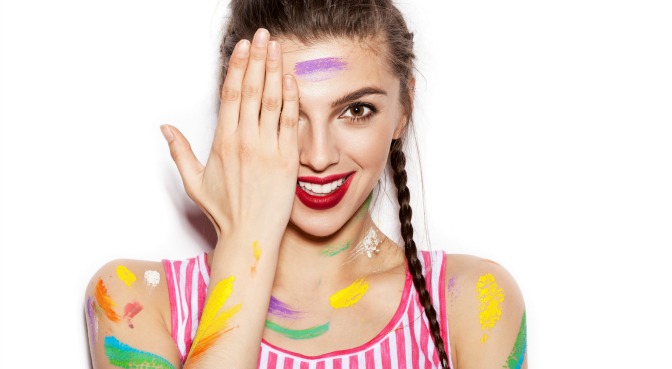 Girl covered in streaks of colored paint