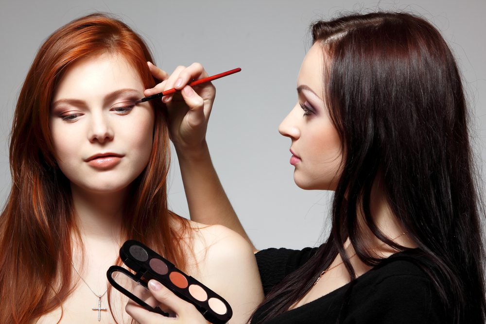 student learning how to become a freelance makeup artist by practicing on friend