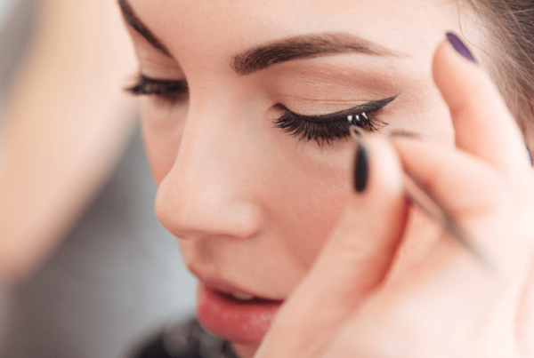 freelance makeup artist applying individual false lashes on client