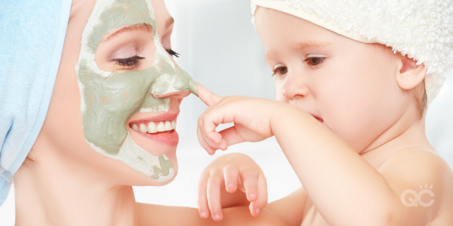 clay mask on mom with her baby touching her face