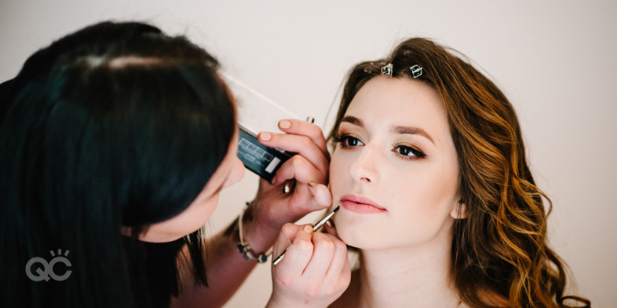 makeup artist applying lip gloss from makeup artist kit