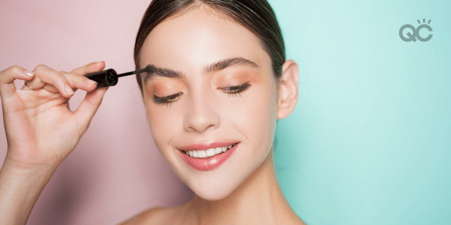 smiling girl brushing her eyebrows