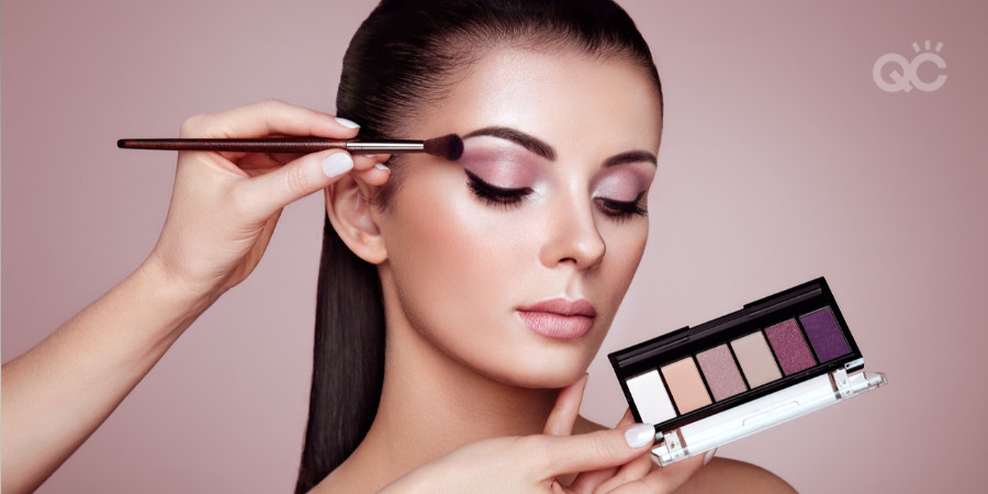 makeup items you don't need - model wearing eyeshadow with eyeshadow palette held up