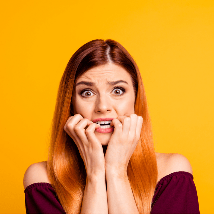 scared worried woman in front of yellow background