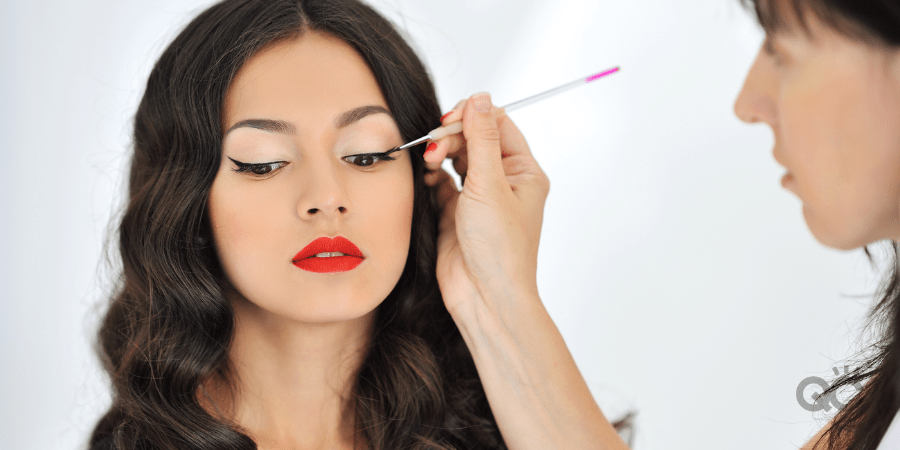 mua applying eye makeup to female model