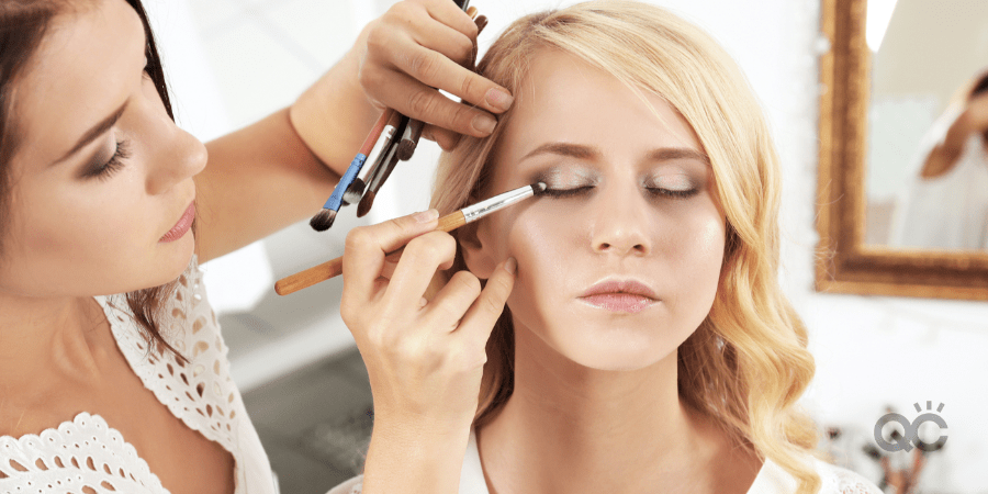 MUA applying eye makeup to model