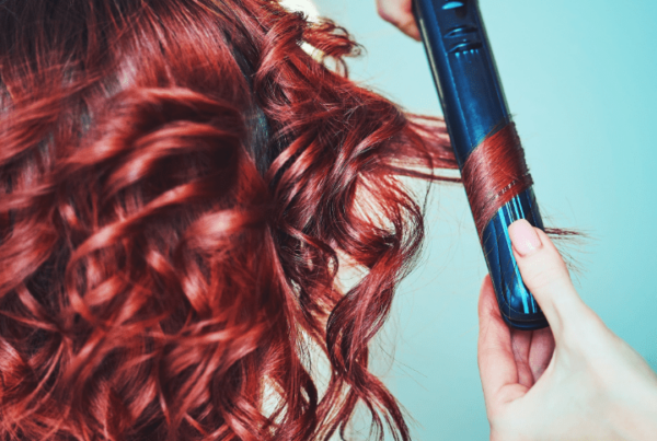 redhead having hair curled with straightener