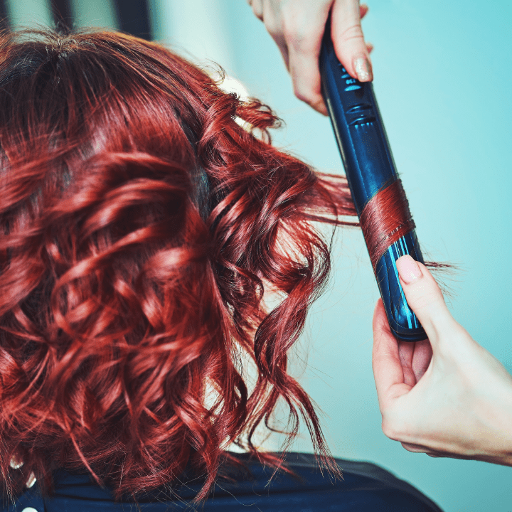 redhead having hair curled with straightener