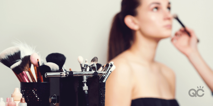 makeup tools, with model having makeup put on her in background