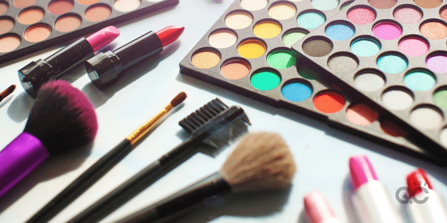 Professional make up set: eyeshadow palette, lipstick, make-up brushes and many cosmetics close up. Film and flare effect.