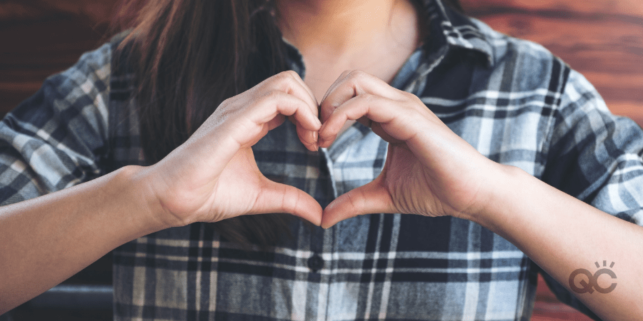 Woman making a heart shape with hands - makeup artist practice article