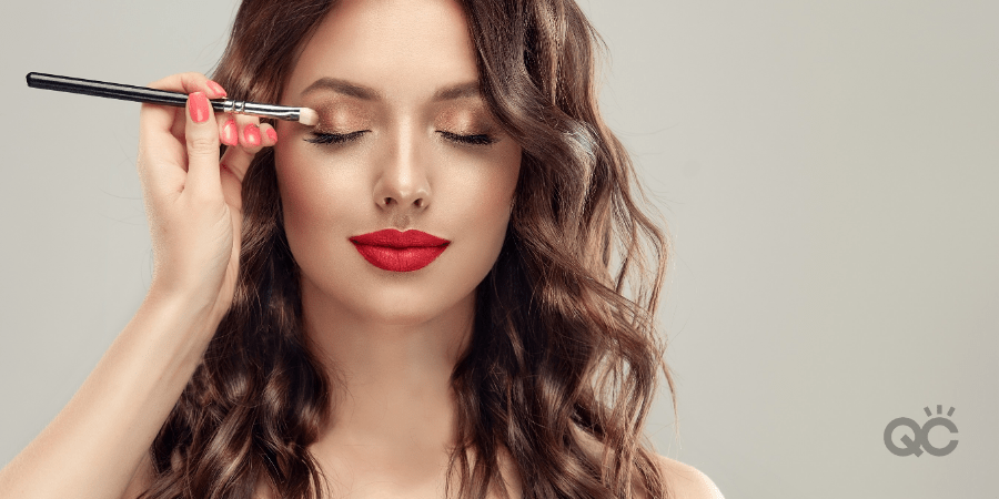 Photo of professional makeup artist's hand applying eyeshadow to model