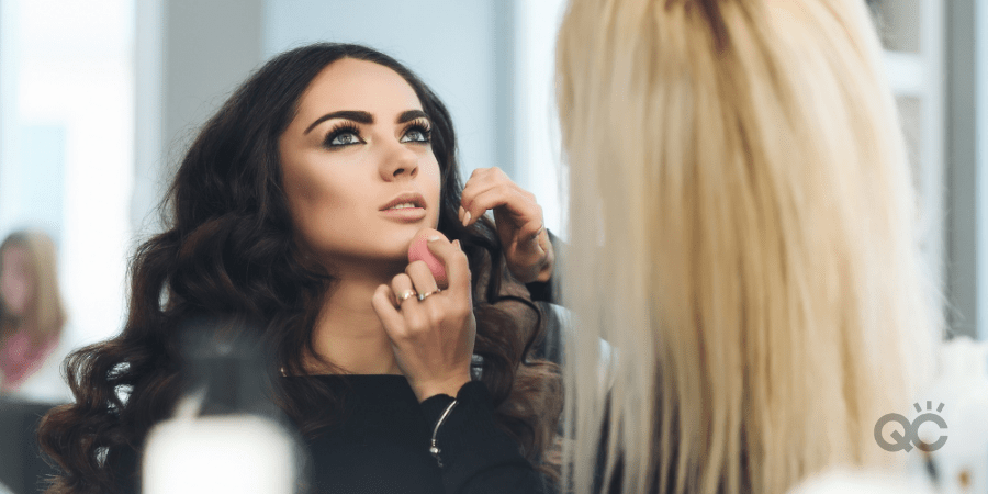 woman learning how to become a makeup artist by getting hands-on training on female model