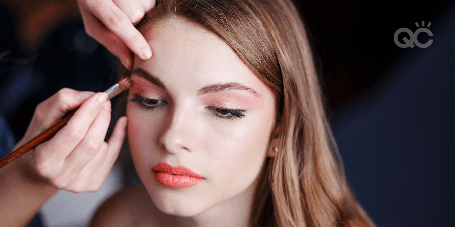 female model having makeup professionally applied by makeup artist