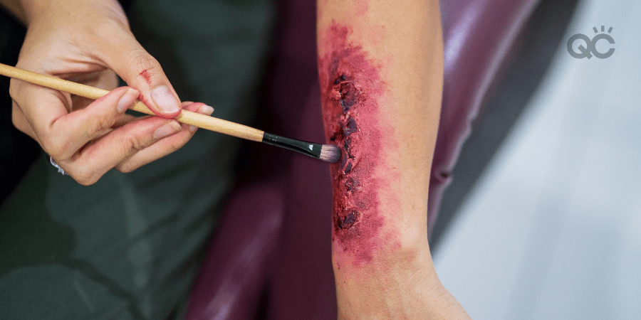 MUA touching up special effects makeup on forearm