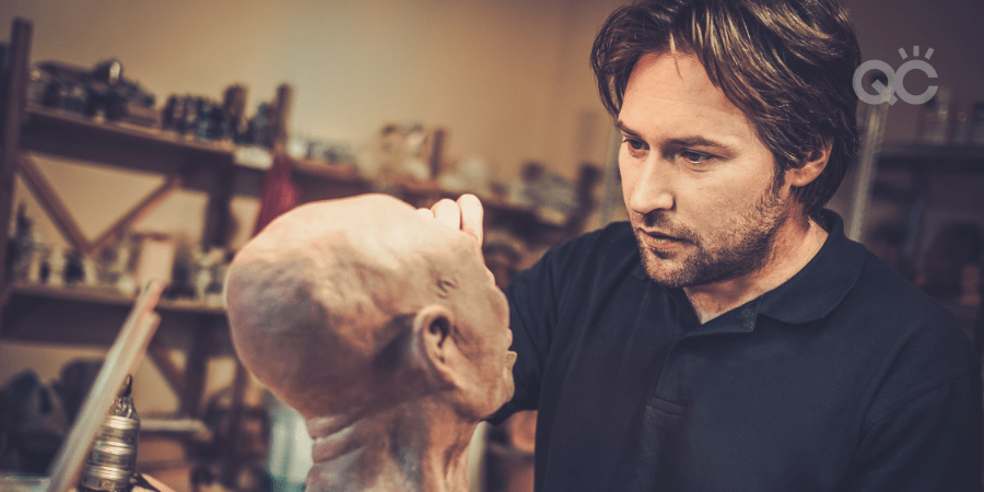 male makeup artist working on prop head