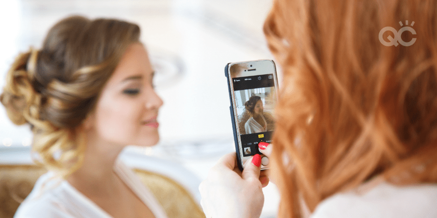 makeup artist taking photo of bridal client