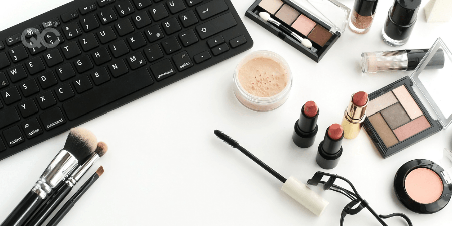 makeup on table with laptop keyboard