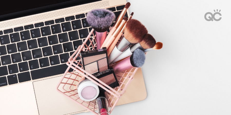 makeup products in mini shopping basket, sitting on laptop