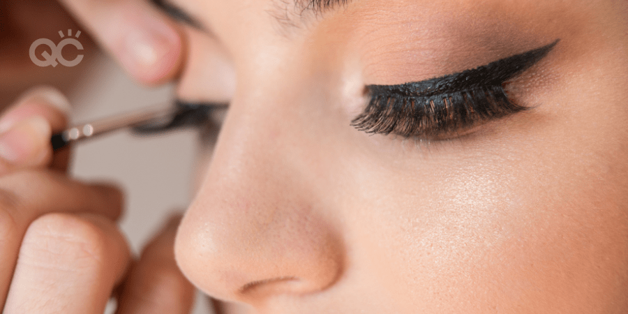 makeup artist applying eyeliner to client