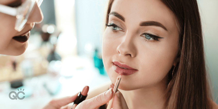 Makeup artist applying lip product to client