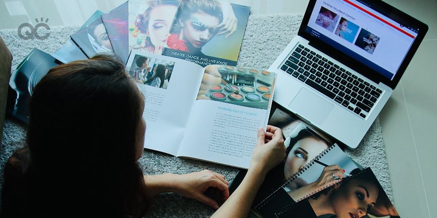 Veronika Kelle surrounded by makeup classes textbooks and laptop, working on studies