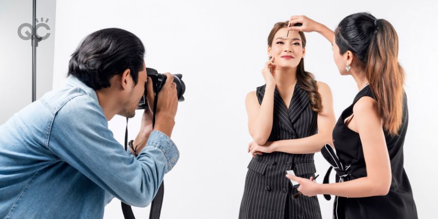 Photographer, makeup artist, and model on set of photoshoot