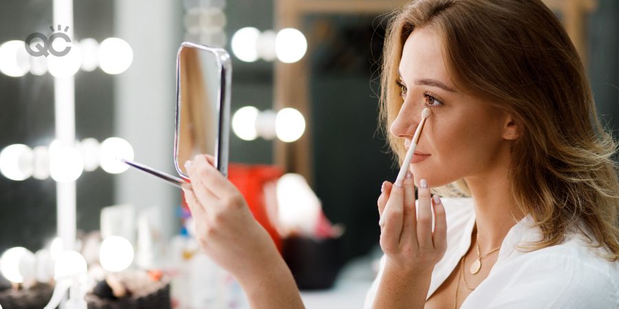 Makeup career article, last in-post image, woman applying makeup to her own face at home