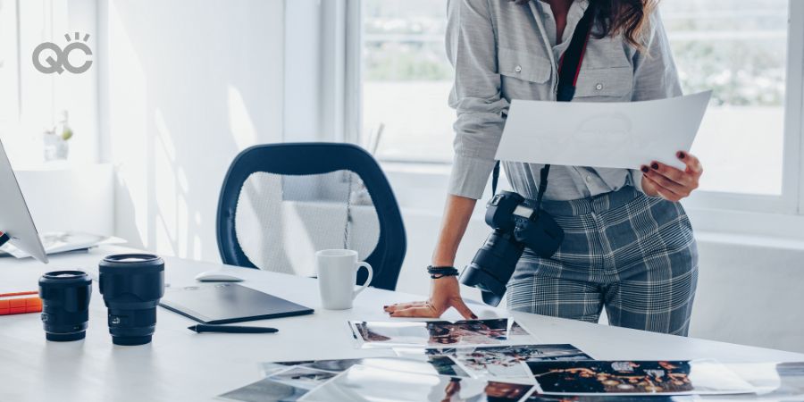 Photographer at desk, looking through selection of prints