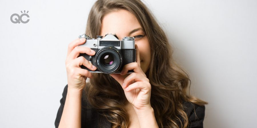 Portrait of fashionable young photographer with vintage film camera.