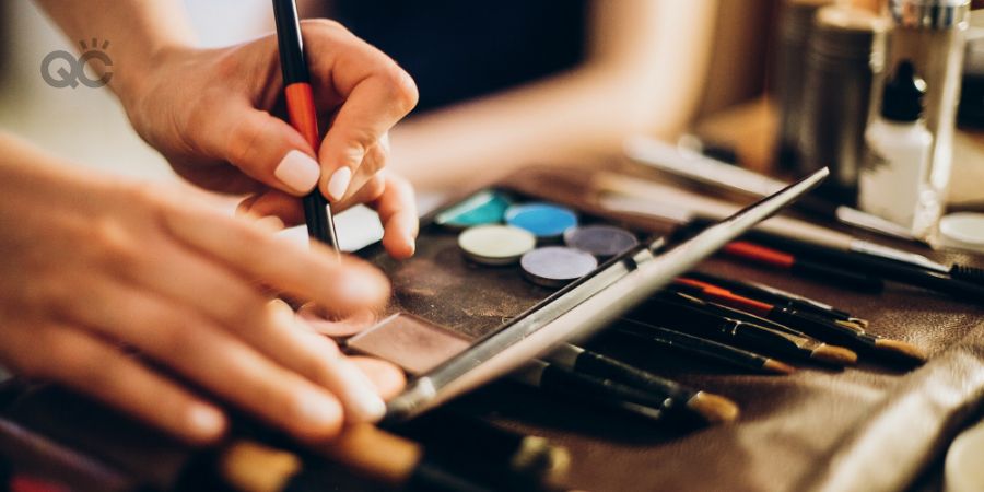 Makeup artist holding brush and eyeshadow palette. makeup artist making gorgeous make-up for bride in the morning. beauty and fashion image. set of brushes, powder, eyeshadows on table