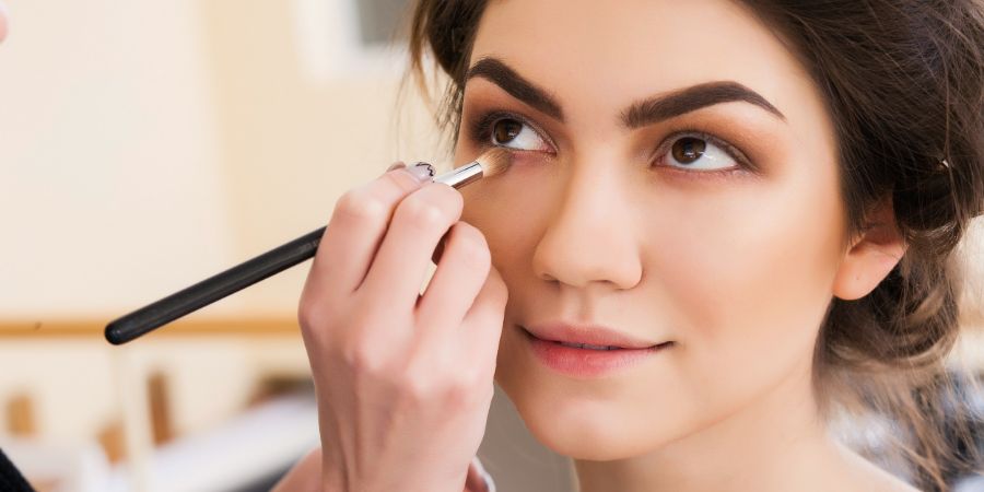 Makeup artist doing makeup beautiful girl in the salon, beauty concept and style