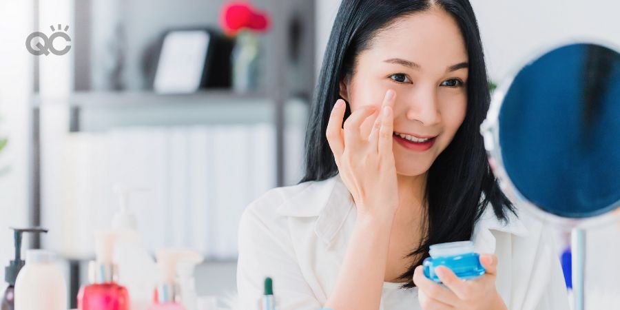 Beautiful asian woman blogger is showing how to make up and use cosmetics. In front of the mirror and recording vlog video live streaming at home.Skincare for healthy face concept.