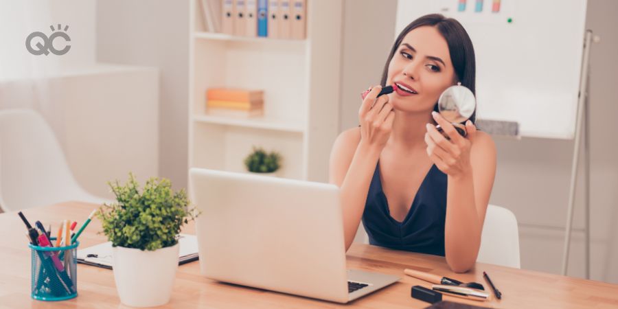 Pretty happy businesswoman doing make up in home office