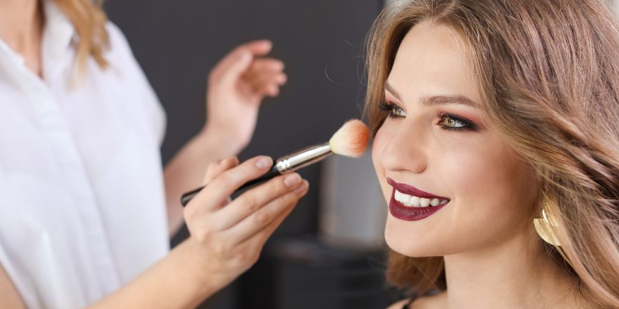 Makeup artist applying makeup to client using makeup theory