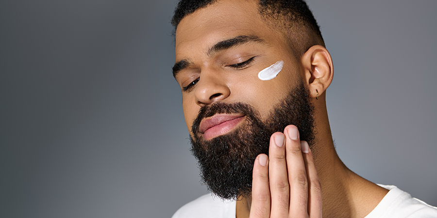 Man showing off his skincare routine, applying moisturizer for men