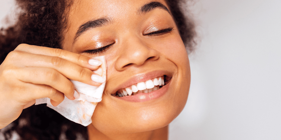 Smiling woman removes makeup using best makeup remover