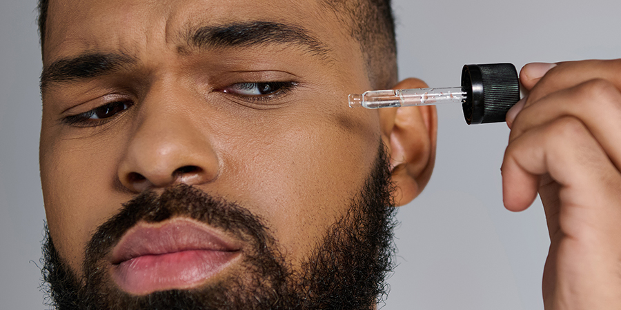 Man holding syringe with male skincare product to optimize his skin.