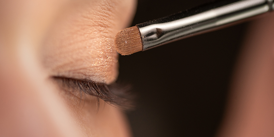 Student attending top cosmetology school practices eyeshadow techniques